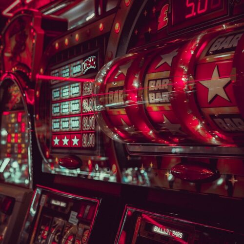 Close-up of vintage slot machines with vibrant red lighting in a casino