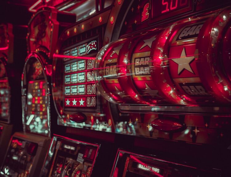 Close-up of vintage slot machines with vibrant red lighting in a casino
